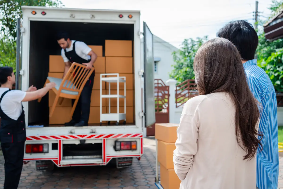 Skilled movers loading home furniture and boxes into moving truck in Dubai